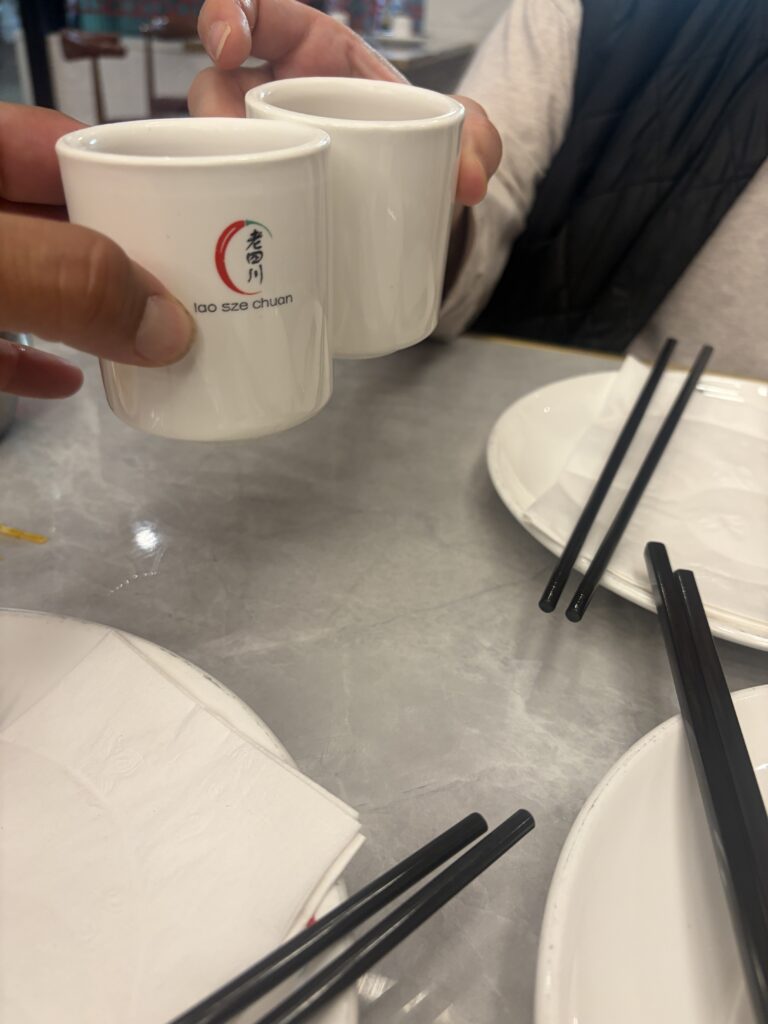 Cheers. The green-tea toast — branded lao sze chuan cups, hot and clean, the way it should be.